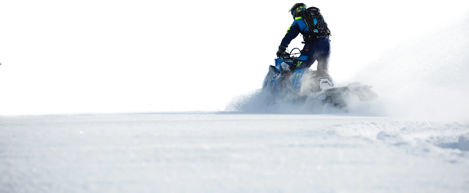 Snowmobile rider plowing through fresh powder